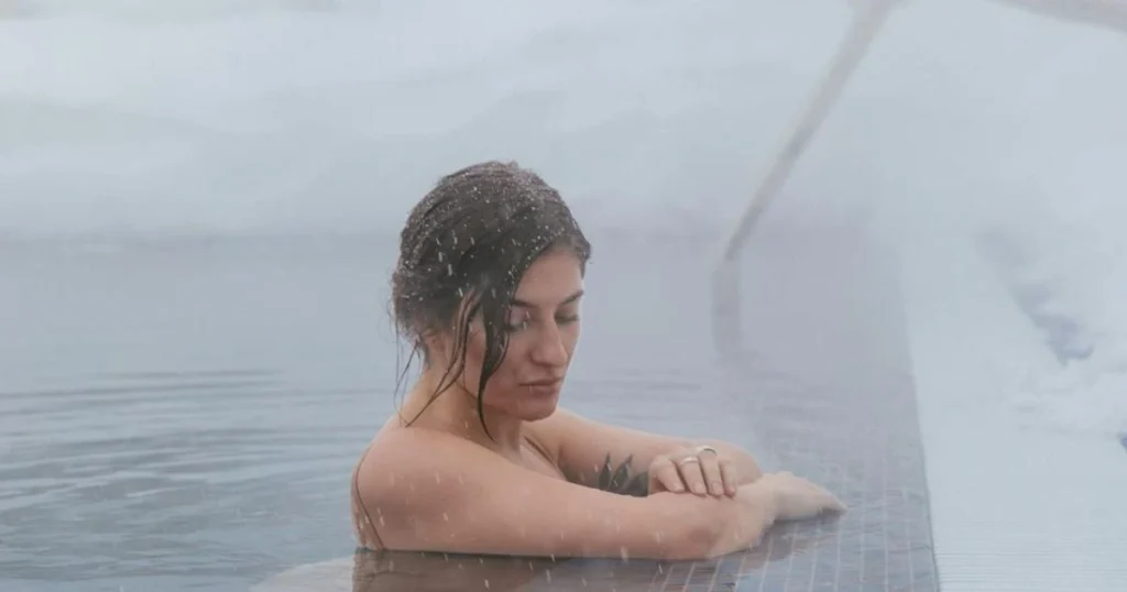 Woman standing in a cold sea during contrast therapy session"