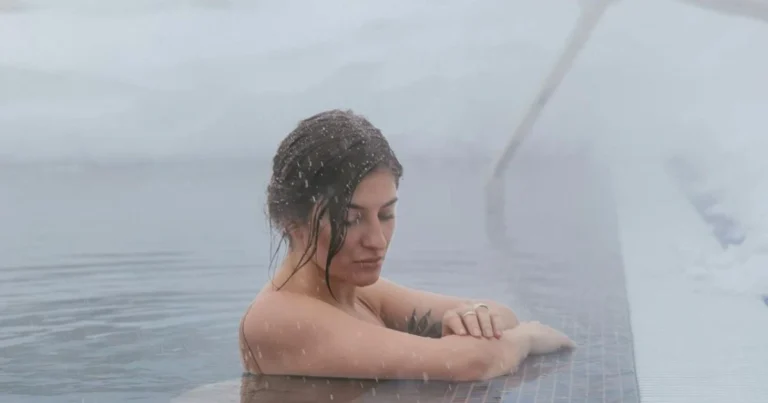 Woman standing in a cold sea during contrast therapy session"